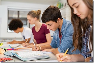 High school students doing exam in classroom