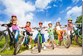 Below angle view of kids in helmets with bikes