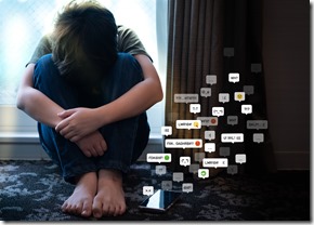 Cyberbullying - social media harassment concept. Young asian preteen, teenager boy sitting alone in the room feeling frustrated after reading bad comments. Text emoticons, Teen mental health, Online.