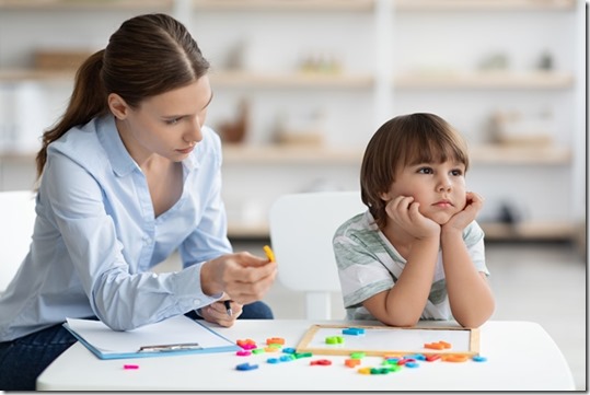 Bored sad little boy refusing to cooperate with teacher, ignoring speech therapist with letters at office, free space