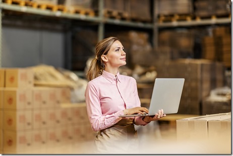 A food industry worker checking on shipment on the laptop in warehouse.