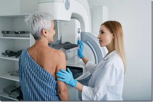 Senior woman having mammography scan at hospital with medical technician. Mammography procedure, breast cancer prevention