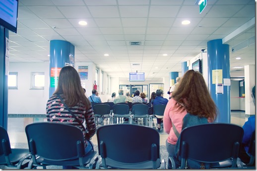 people in a waiting room of hospital, men and women wait their turn 