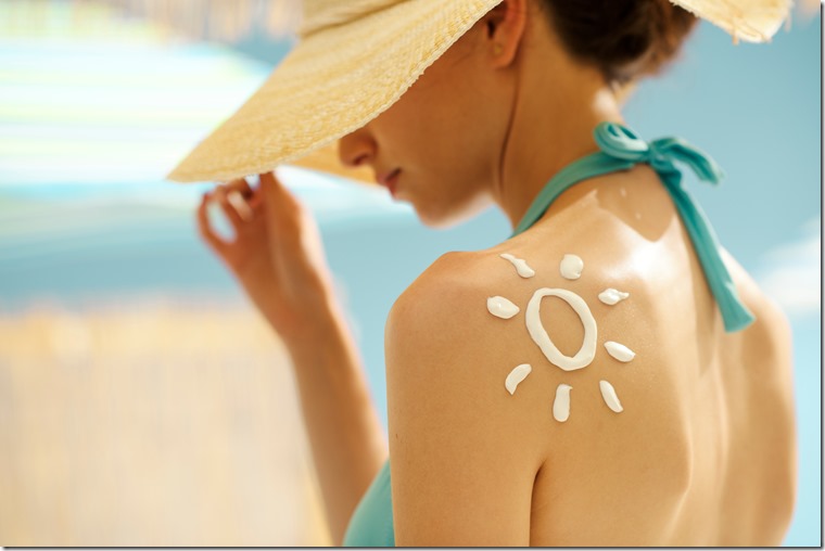 Woman tanning at the beach with sunscreen cream