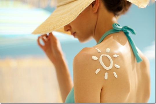 Woman tanning at the beach with sunscreen cream